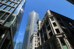Upward view of London's modern skyscrapers under a clear blue sky.